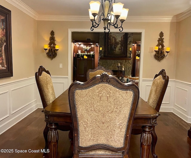 dining space with a notable chandelier, crown molding, and a decorative wall