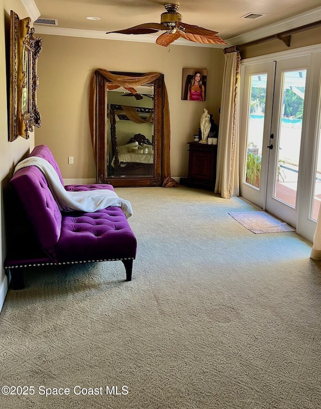 living area with carpet flooring, french doors, visible vents, and ornamental molding