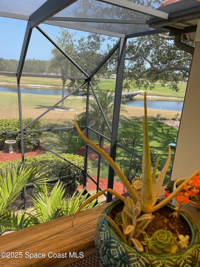 sunroom featuring a water view