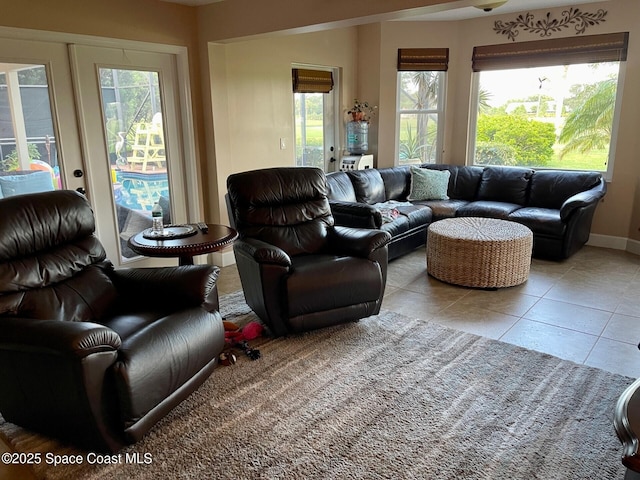 living area with tile patterned floors, french doors, and baseboards