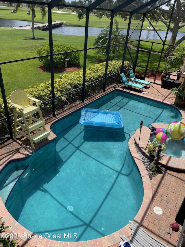 outdoor pool featuring a patio area, glass enclosure, and a water view