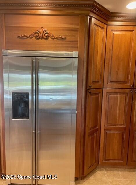 kitchen featuring light tile patterned flooring, brown cabinets, and high end refrigerator