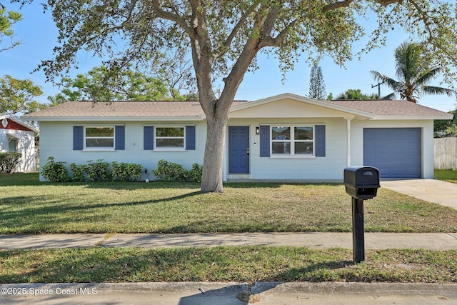 ranch-style home with a shingled roof, concrete driveway, a garage, and a front lawn