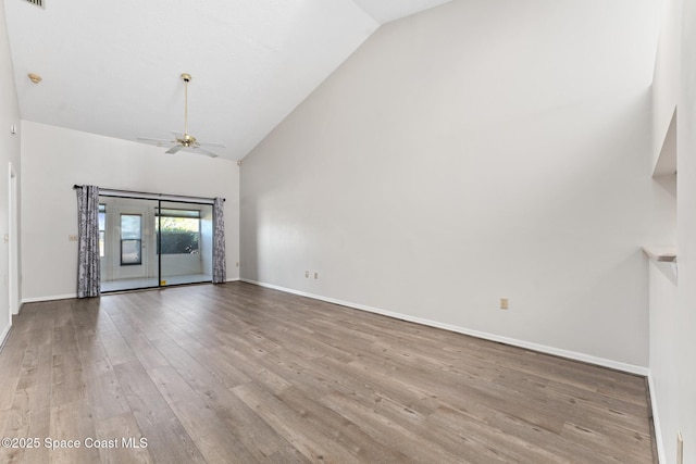 spare room with visible vents, baseboards, ceiling fan, wood finished floors, and high vaulted ceiling