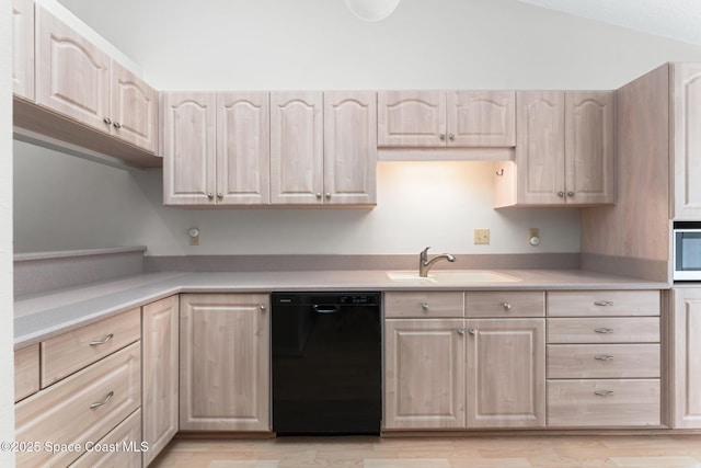 kitchen featuring light brown cabinetry, a sink, light wood finished floors, dishwasher, and light countertops