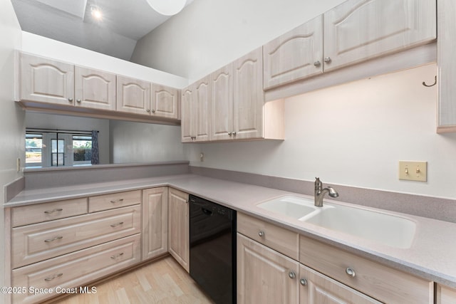 kitchen featuring light brown cabinetry, a sink, black dishwasher, light countertops, and lofted ceiling