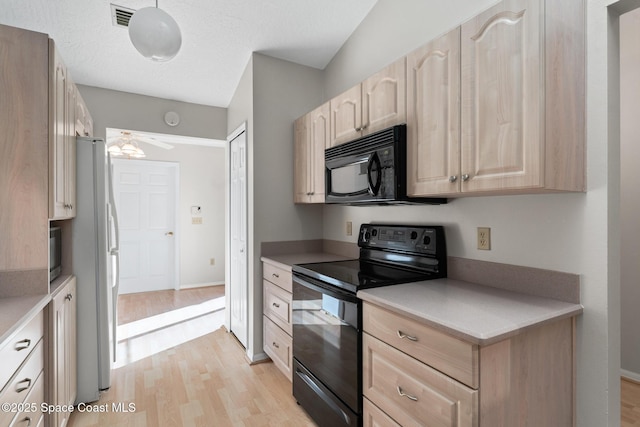 kitchen with visible vents, black appliances, light brown cabinetry, light wood-style floors, and light countertops