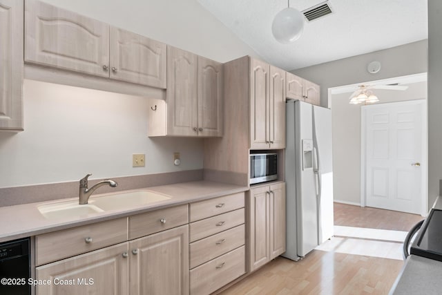 kitchen featuring a sink, visible vents, white refrigerator with ice dispenser, and light brown cabinets