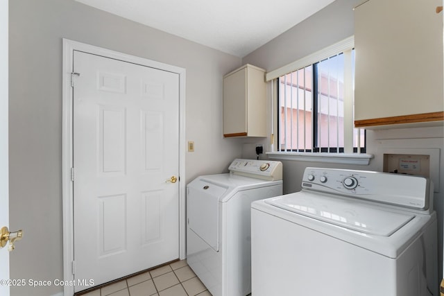 laundry room with light tile patterned floors, cabinet space, and washer and clothes dryer