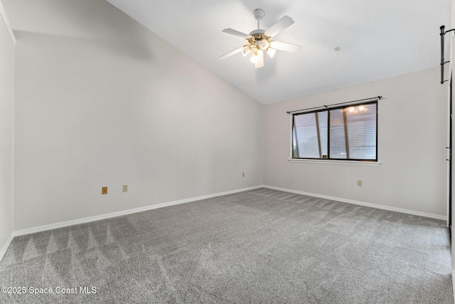 empty room with lofted ceiling, carpet flooring, a ceiling fan, and baseboards