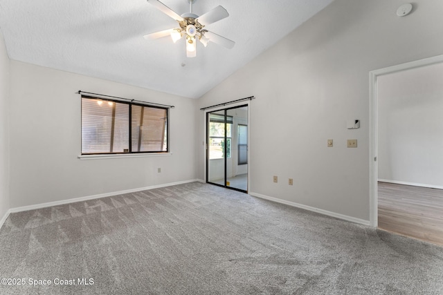 carpeted empty room with baseboards, lofted ceiling, a textured ceiling, and ceiling fan