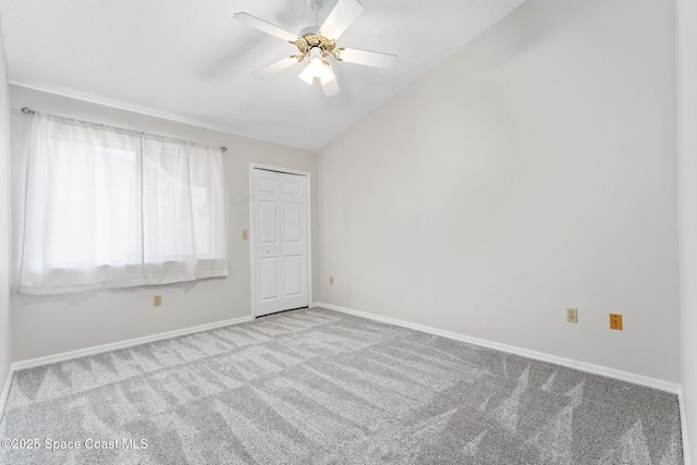 unfurnished room with baseboards, carpet, ceiling fan, and vaulted ceiling