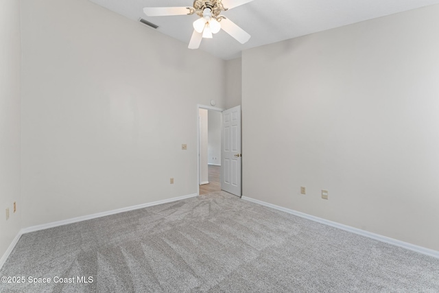 empty room featuring baseboards, visible vents, lofted ceiling, ceiling fan, and carpet flooring