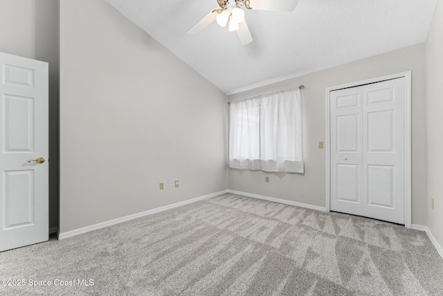 unfurnished bedroom featuring baseboards, a ceiling fan, lofted ceiling, and carpet floors