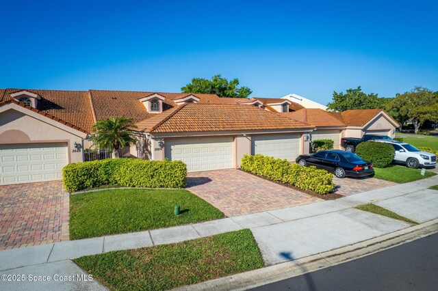 view of front of home featuring stucco siding, driveway, and a tile roof