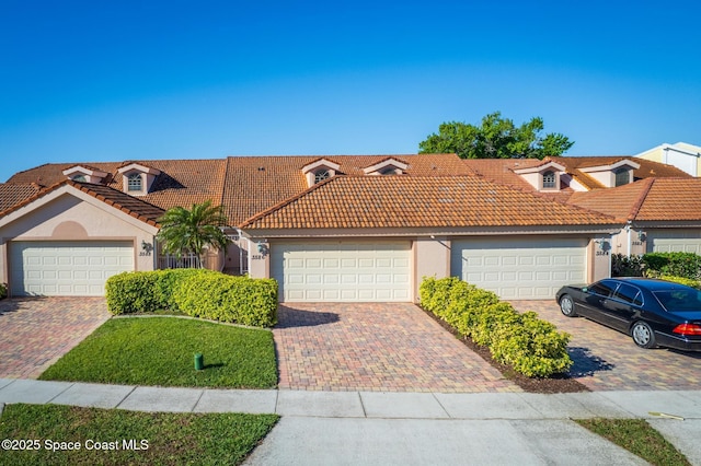 view of front facade with stucco siding, driveway, and a tiled roof