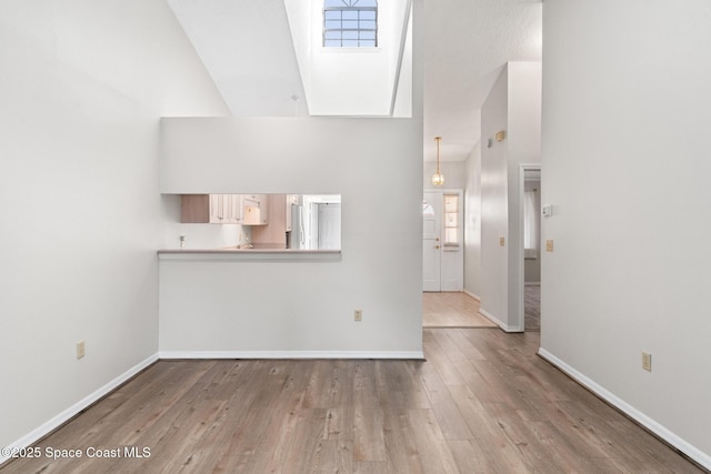 unfurnished living room featuring baseboards and wood finished floors