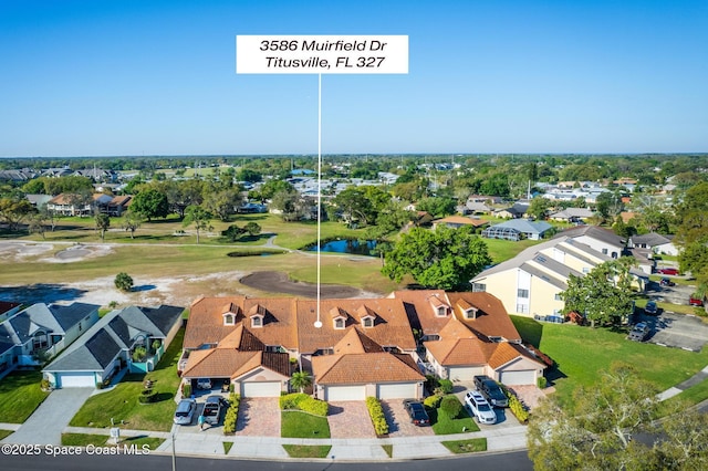 drone / aerial view with view of golf course and a residential view