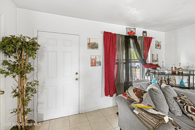 foyer entrance with light tile patterned floors and baseboards