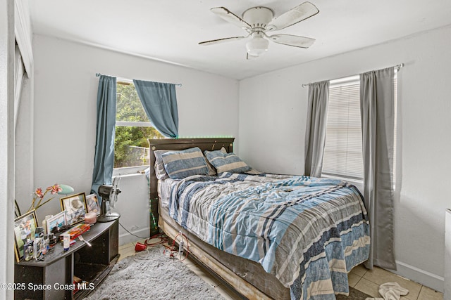 bedroom featuring tile patterned floors, baseboards, and a ceiling fan