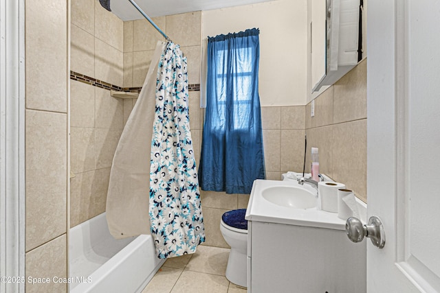 bathroom featuring tile patterned flooring, shower / bath combo with shower curtain, toilet, vanity, and tile walls