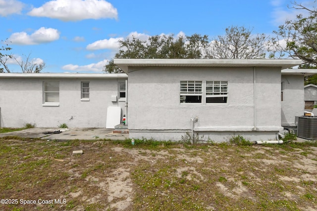 back of house featuring stucco siding, central AC, and a patio