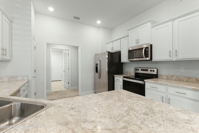 kitchen featuring visible vents, white cabinets, appliances with stainless steel finishes, and light countertops