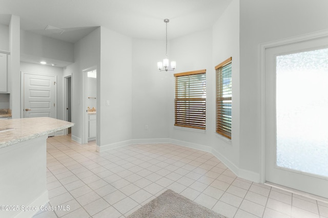 unfurnished dining area with light tile patterned floors, baseboards, and an inviting chandelier