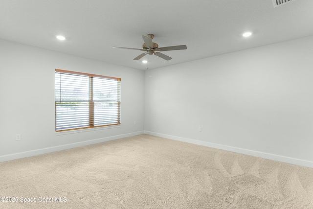 empty room featuring a ceiling fan, recessed lighting, light colored carpet, and baseboards