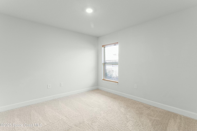 empty room featuring baseboards and carpet