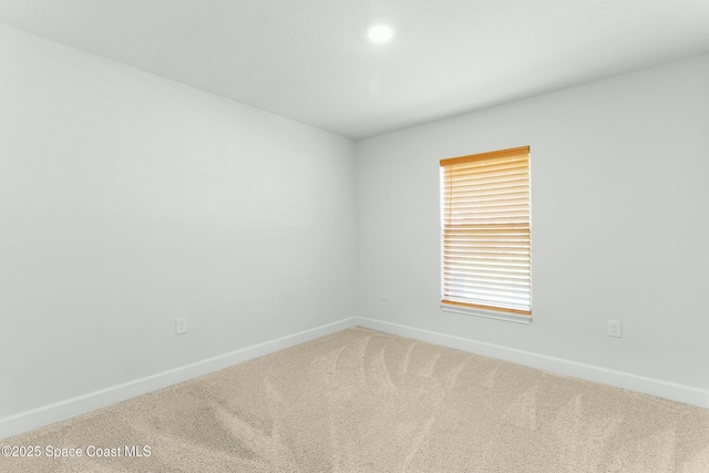 empty room with baseboards and carpet