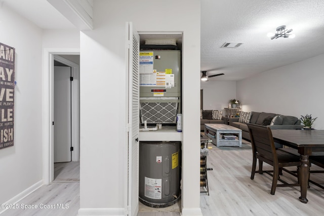 utility room featuring visible vents and electric water heater