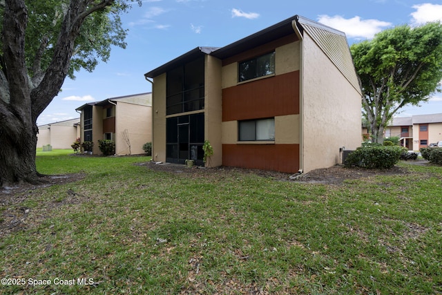 rear view of house with a yard and stucco siding