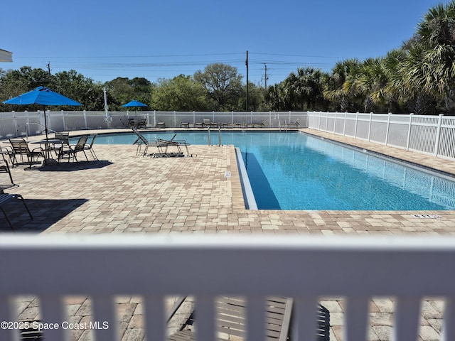 community pool featuring fence and a patio area