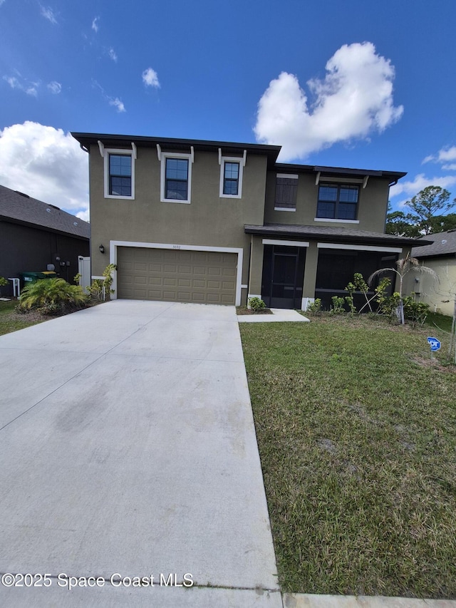 view of front facade with a front yard, a garage, driveway, and stucco siding