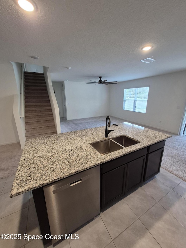 kitchen with stainless steel dishwasher, light colored carpet, open floor plan, and a sink