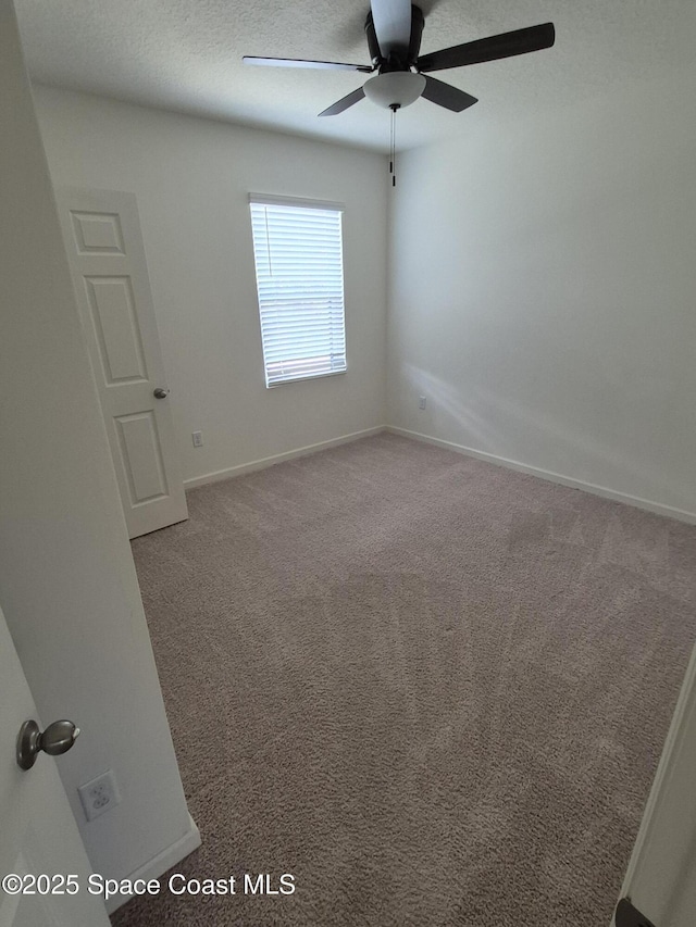 carpeted spare room with baseboards, a textured ceiling, and a ceiling fan