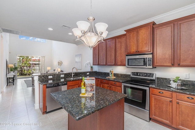 kitchen with visible vents, a peninsula, a notable chandelier, stainless steel appliances, and a sink