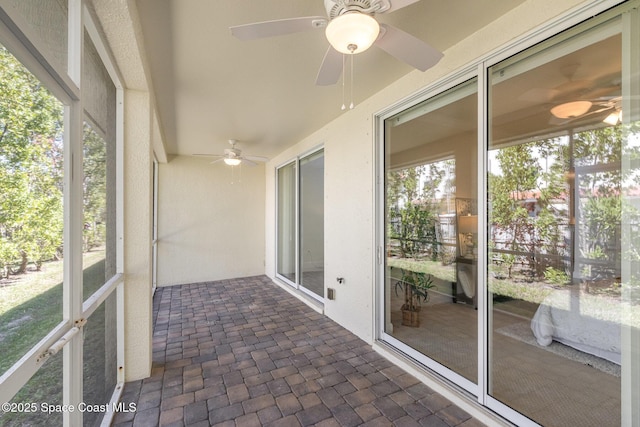 unfurnished sunroom with a ceiling fan