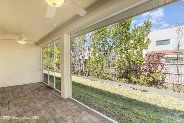 unfurnished sunroom with a ceiling fan