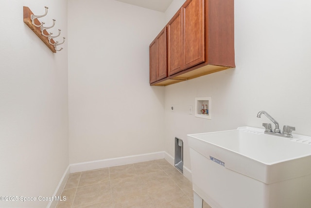 laundry room featuring hookup for a washing machine, baseboards, light tile patterned flooring, cabinet space, and a sink