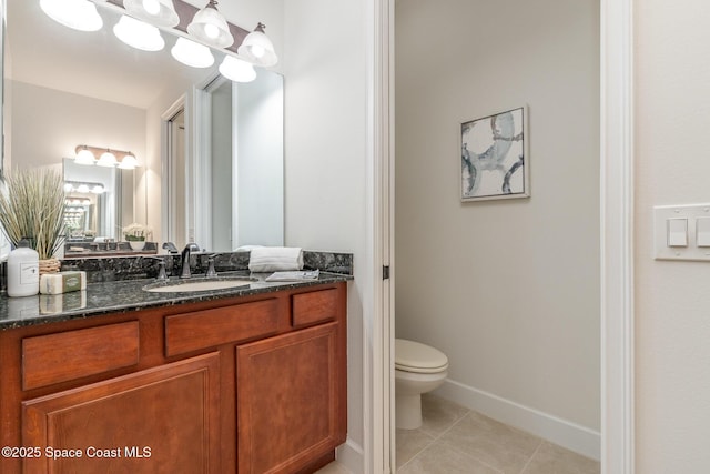 bathroom featuring vanity, tile patterned floors, toilet, and baseboards