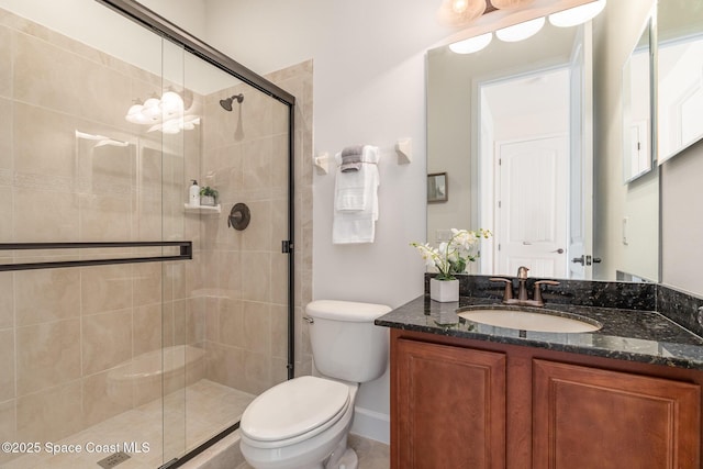 bathroom featuring vanity, a shower stall, and toilet