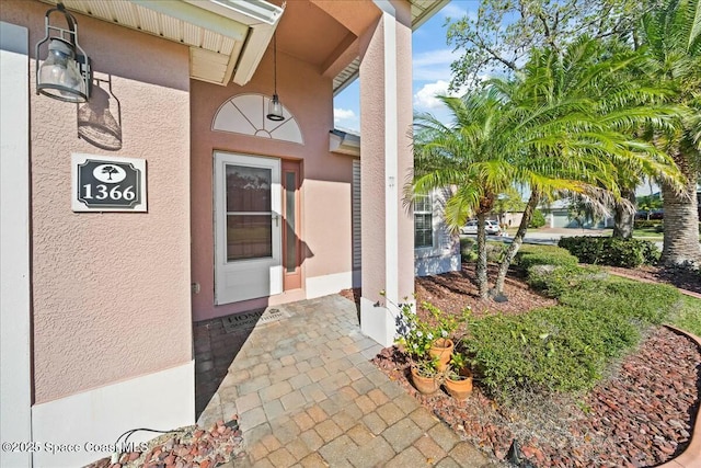 entrance to property featuring stucco siding