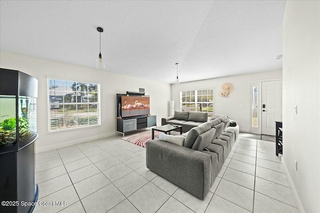 living room featuring light tile patterned floors, baseboards, and a textured ceiling