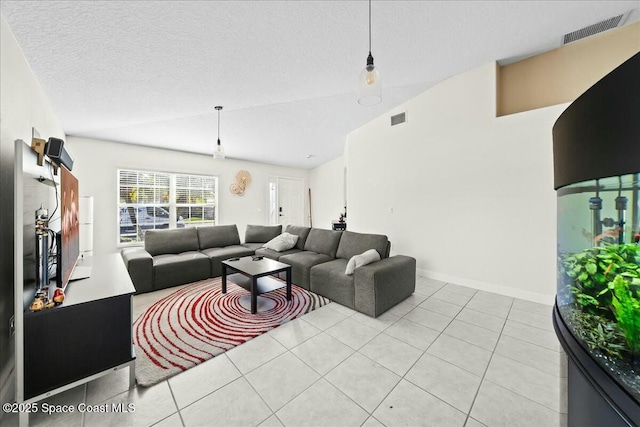 living room featuring light tile patterned floors, visible vents, a textured ceiling, and vaulted ceiling