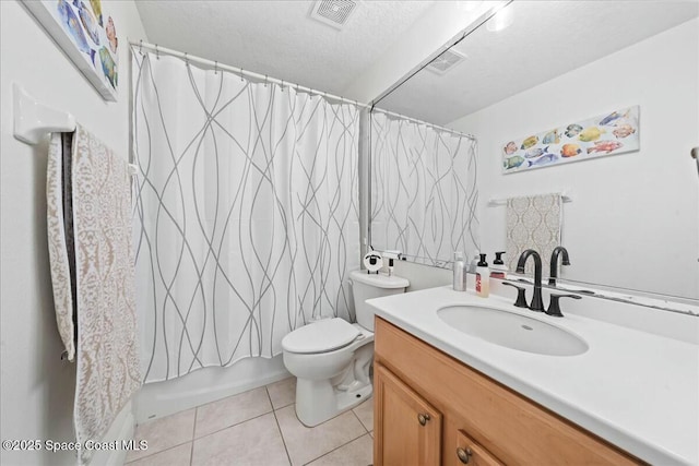 bathroom with visible vents, toilet, vanity, tile patterned floors, and a textured ceiling