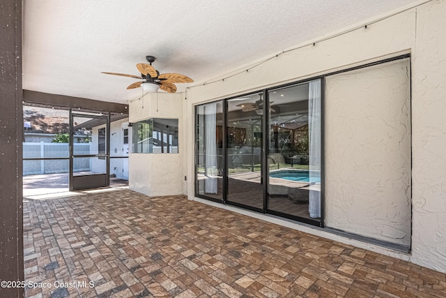 exterior space with glass enclosure and a ceiling fan