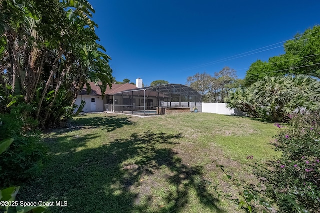 view of yard with glass enclosure, a pool, and a fenced backyard