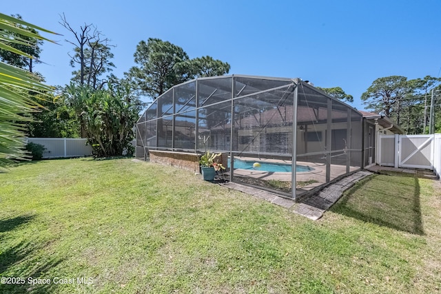 view of yard with a gate, a patio, a fenced backyard, glass enclosure, and a fenced in pool